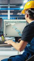 Vertical Photovoltaics factory engineer using artificial intelligence to monitor performance of robot arms placing solar panels on assembly lines. Expert using AI tech to inspect solar plant machinery video