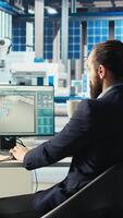 Vertical Photovoltaics factory manager walking to employees desks to give tasks after visualizing solar cells designs with 3D software tools, shaping facility floor according to computer simulations video