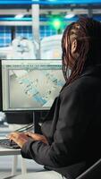 Vertical Photovoltaics factory programmer analyzing data with machine learning tech, reviewing system metrics. Solar panels plant developer coding app troubleshooting technical issues, camera A video