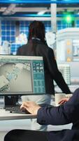 Vertical Engineer in photovoltaics factory using PC screen to diagnose malfunctioning systems. Solar panels manufacturing plant worker at computer desk maintaining system operational reliability, camera A video