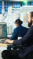 Vertical Photovoltaics factory manager arriving in office, visualizing solar cells designs with 3D software on PC. Solar panels plant technician sits down at desk, starting computer simulations in CAD program video