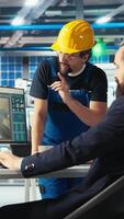 Vertical Photovoltaics factory manager showing engineer on PC screen how to adjust system parameters. Specialist showing staff member how to optimize energy supply in solar panel manufacturing plant, camera A video
