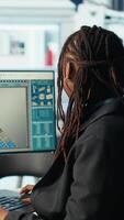 Vertical Photovoltaics factory programmer analyzing data with machine learning tech, reviewing system metrics. Solar panels plant developer coding app troubleshooting technical issues, camera B video