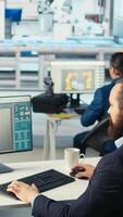 Vertical Engineer in photovoltaics factory reviews paperwork to diagnose malfunctioning systems. Solar panels manufacturing plant worker reading inspection data files to reduce downtime, camera A video