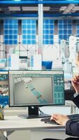 Vertical Photovoltaics factory manager reviews paperwork of robot arms performance placing solar panels on assembly lines. Supervisor reads inspection data files of solar plant machinery parameters video