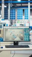 Vertical PC on desk in empty photovoltaics factory used for analyzing data and reviewing system metrics. Computer in solar panels manufacturing plant troubleshooting technical issues, diagnosing faults video