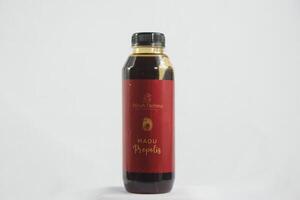 Thick and rich honey cascading from a jar, highlighting its pure texture and golden color, set against a wooden backdrop photo