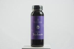 A bottle of purple syrup on a white surface photo