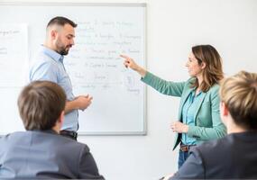 A man and woman are standing in front of a whiteboard photo