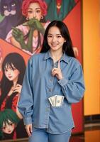 A woman in a denim shirt and jeans poses for the camera photo