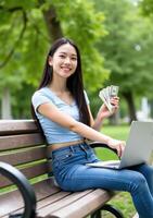 A woman sitting on a bench with a laptop and money photo