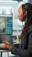 Vertical Programmer in photovoltaics factory using PC program to diagnose malfunctioning systems. Woman coding at computer desk in solar panels manufacturing plant, reducing downtime, camera B video