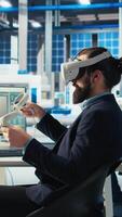 Vertical Photovoltaics factory worker using VR headset to monitor performance of robot arms placing solar panels on assembly lines. Expert inspecting solar plant machinery using virtual reality technology video