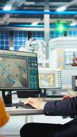 Vertical Photovoltaics factory team leader gives workers tasks after analyzing system health metrics. Solar panels plant manager tells employees fixes to make after troubleshooting technical issues, camera A video