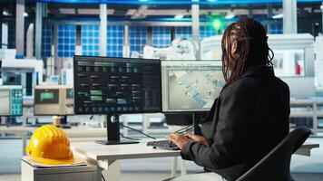 Photovoltaics factory programmer analyzing data with machine learning tech, reviewing system metrics. Solar panels plant developer coding app troubleshooting technical issues, camera A video