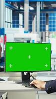 Vertical Photovoltaics factory worker analyzing data on green screen PC, reviewing system metrics. Solar panels manufacturing plant employee troubleshooting technical issues using chroma key computer, camera A video