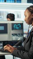 Vertical Photovoltaics factory programmer analyzing data using artificial intelligence, reviewing system metrics. Solar panels plant technician troubleshooting technical issues using AI technology, camera B video