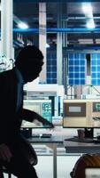 Vertical Hacker sneaking into solar panel facility, inserting USB stick into PC to steal secret manufacturing data. Thief bypasses photovoltaics factory security, extracting company files, camera A video