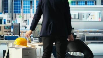 Photovoltaics factory manager arriving in office, visualizing solar cells designs with 3D software on PC. Solar panels plant technician sits down at desk, starting computer simulations in CAD program video