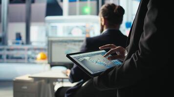 Photovoltaics factory specialist designs production lines in CAD app using tablet. Solar panels plant technician uses simulation software on device to optimize production layouts, camera A closeup video