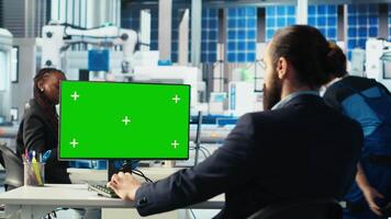 Photovoltaics factory engineer using chroma key PC improving solar panels efficiency. Solar panels manufacturing plant worker researching sustainable solar solutions using mockup computer, camera B video