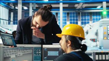 Photovoltaics factory engineer working in CAD software, brainstorming with manager. Solar panels manufacturing plant technician designing assembly lines, informing supervisor, camera B video