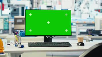 Isolated screen PC in photovoltaics factory used to monitor performance of robot arms manufacturing solar panels. Chroma key mockup computer in empty facility used to inspect solar plant machinery video