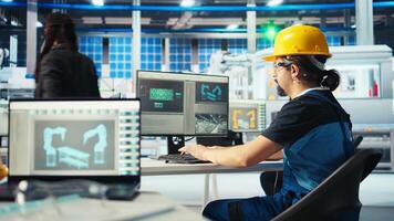 Photovoltaics factory manager shows engineer improvements to be made of robot arms manufacturing solar panels. Man shows technician upgrades needed after inspecting solar plant machinery, camera A video