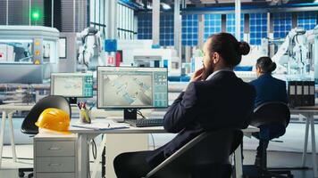 Photovoltaics factory engineer taking notes of adjustments to make after analyzing system metrics. Solar panels plant technician writing production plans after troubleshooting technical issues video