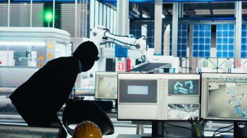 Hacker sneaking into solar panel facility, inserting USB stick into PC to steal secret manufacturing data. Thief bypasses photovoltaics factory security, extracting company files, camera B video