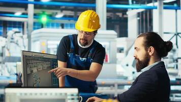 Photovoltaics factory manager delegating tasks to employee, improving solar panels efficiency. Team leader sends worker to make adjustments after researching more sustainable solar solutions, camera B video