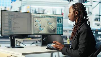 Programmer in photovoltaics factory using PC program to diagnose malfunctioning systems. Woman coding at computer desk in solar panels manufacturing plant, reducing downtime, camera B video