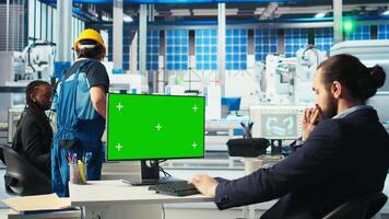 Engineer in photovoltaics factory using chroma key computer to diagnose malfunctioning systems. Solar panels manufacturing plant worker reducing downtime using green screen PC, camera A video