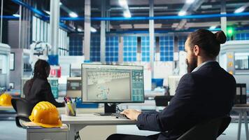 Photovoltaics factory engineer analyzing data on PC screen, reviewing system health metrics. Solar panels plant employee troubleshooting technical issues at computer desk, diagnosing faults, camera A video
