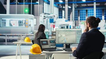 Photovoltaics factory technician adjusts system parameters on laptop to maximize solar cells power generation. Man using notebook optimizing energy supply in solar panel manufacturing plant, camera A video