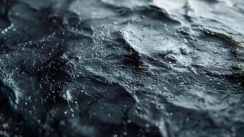 A close up of a black rock with water droplets photo