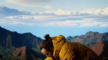 Trekker in warm clothing takes in the sweeping mountain scenic view, feeling the sense of freedom that comes with high altitude exploration. Nature lover enjoys fresh air. Camera B. video