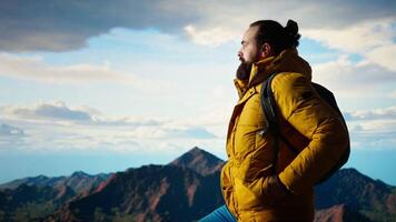 Trekker in warm clothing gazes at the panoramic mountain range, embracing the sense of adventure and the personal growth that comes with exploring most breathtaking landscapes. Camera A. video