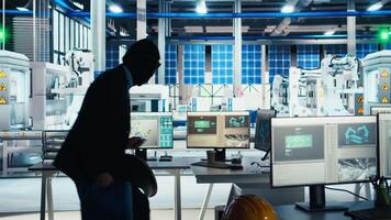 Masked worker in photovoltaics factory commits corporate espionage, stealing proprietary technology using USB stick. Man exploits insider access to copy trade secrets from solar panel plant, camera A video