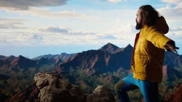 Adventure seeker stands at the peak with the satisfaction of a successful climb, being proud and enjoying the crisp wind at the mountain top. Loving the freedom and nature. Camera A. video