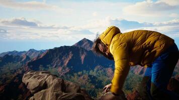 Hiker battling strong winds and cold weather tumbles over a cliff on the mountain top, dangerous risky place for trekking. Unprepared adventure seeker being foolish and tripping. Camera A. video