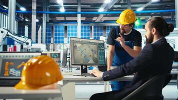 Photovoltaics factory manager showing engineer on PC screen how to adjust system parameters. Specialist showing staff member how to optimize energy supply in solar panel manufacturing plant, camera A video
