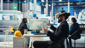 Photovoltaics factory worker using VR headset to monitor performance of robot arms placing solar panels on assembly lines. Expert inspecting solar plant machinery using virtual reality technology video
