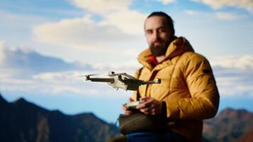 Trekking enthusiast captures his activity on using a drone footage, documenting the scenic mountain range valley. Filming beautiful aerial view vlog with remote control device. Camera B. video