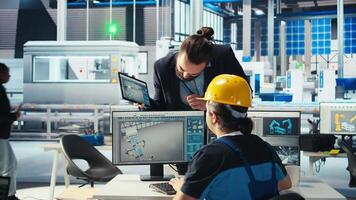 Photovoltaics factory engineer working in CAD software, brainstorming with manager. Solar panels manufacturing plant technician designing assembly lines, informing supervisor, camera A video