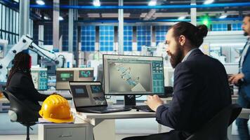 Photovoltaics factory worker monitors system performance, drinking coffee. Solar panels manufacturing plant employee enjoys beverage while using PC to track energy production and efficiency, camera A video