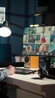 Vertical Black guy meeting with group of individuals on web conference, uses technology for virtual communication. Freelancer working remotely, online meetings or classes in a cozy home. Camera A. video