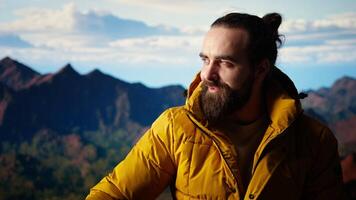 Satisfied adventurer celebrates personal success on a mountain peak, taking a breath and enjoying the scenic view at the top. Motivation for adventure and outdoor exploration. Camera A. video