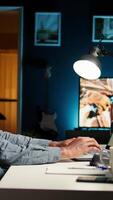 Vertical African American freelancer researching data driven topics at his home workstation, planning work schedule and completing project tasks. Managing job from a comfortable setup. Camera A. video