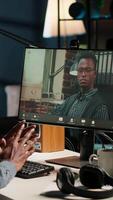 Vertical African American young guy meeting with his boss to discuss task completion, enjoying remote job from the comfort of his modern loft. Waving on a call online, briefing session. Camera B. video
